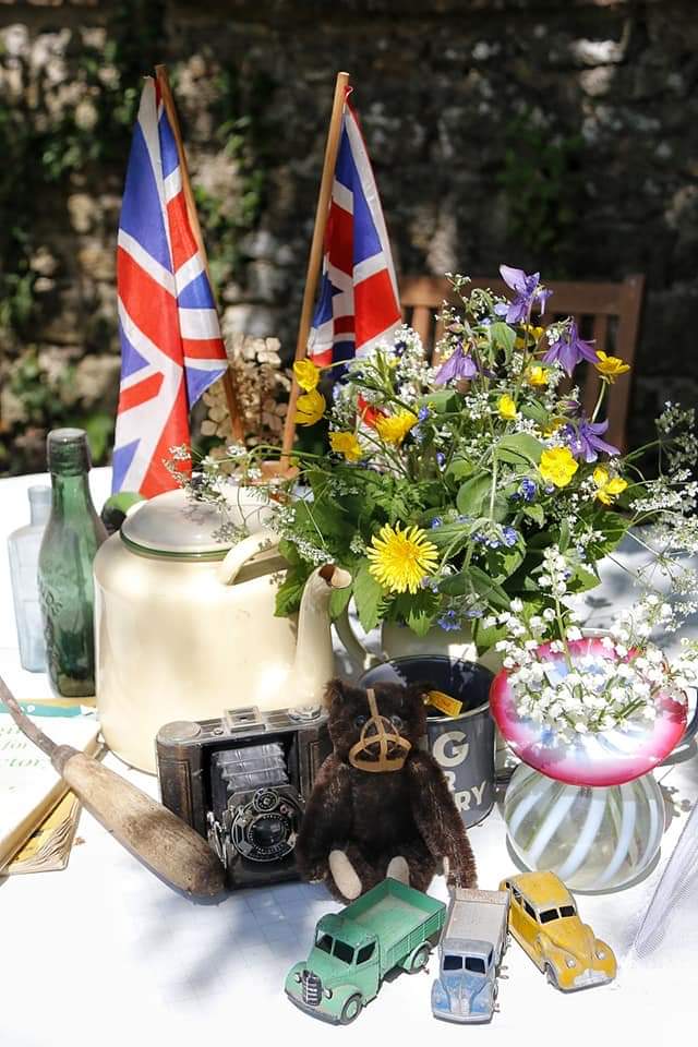 A photo of a VE day display of flowers, flags and tea